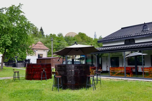 Butoaie mari folosite ca mese, sub o umbrelă