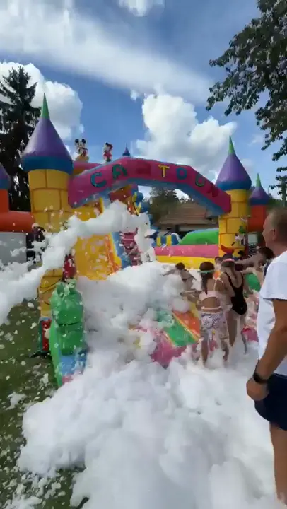 Copii la petrecerea cu spumă, pe tobogan