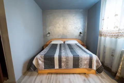 Cameră cu pat dublu și perdele albe
