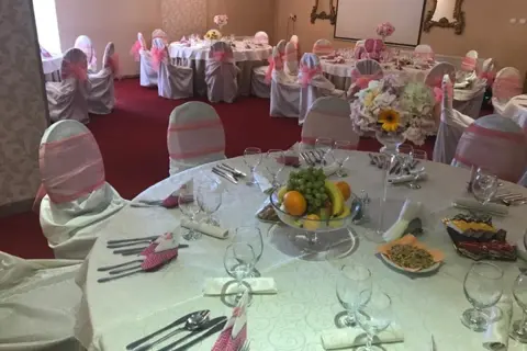 Masă rotundă aranjată pentru nuntă, cu fructe și flori