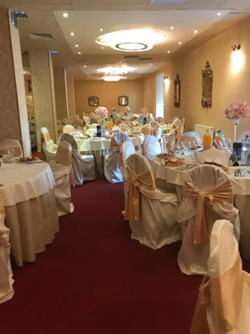 Sala lungă, cu scaune îmbrăcate și perdele aurii
