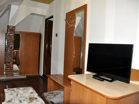 Cameră cu televizor mare și scaune îmbrăcate în blană