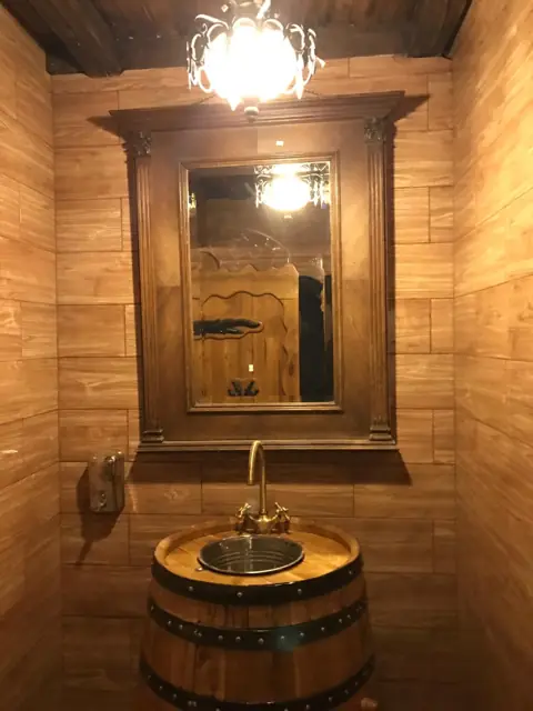 Lavoar dintr-un butoi, sub o oglindă cu ramă de lemn