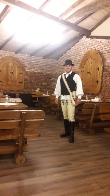Ospătar în costum popular, în sala de cărămidă