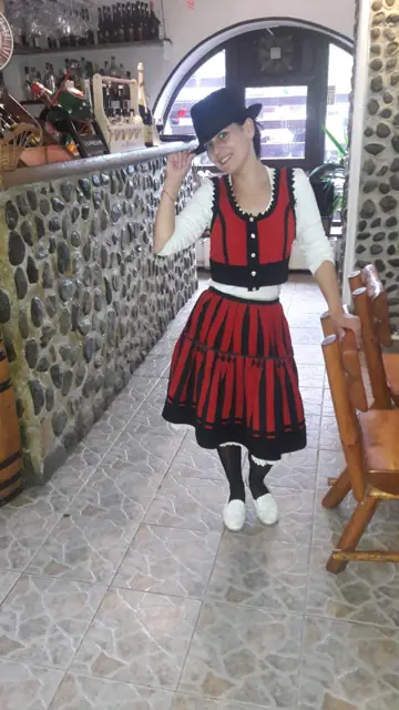 Ospătăriță în costum popular, lângă barul de piatră