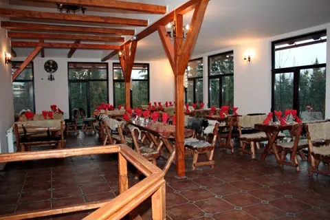 Sala restaurantului văzută de pe scară, cu grinzi de lemn