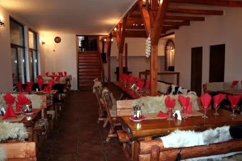 Restaurantul de la etaj, cu grinzi de lemn și mese aranjate